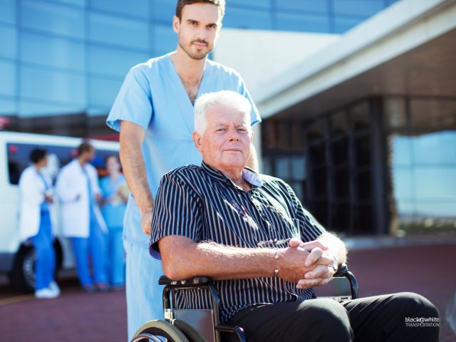 A Nurse Assisting a Patient on a Wheelchair Outside a Hospital, Waiting for Reliable Wheelchair Van Service