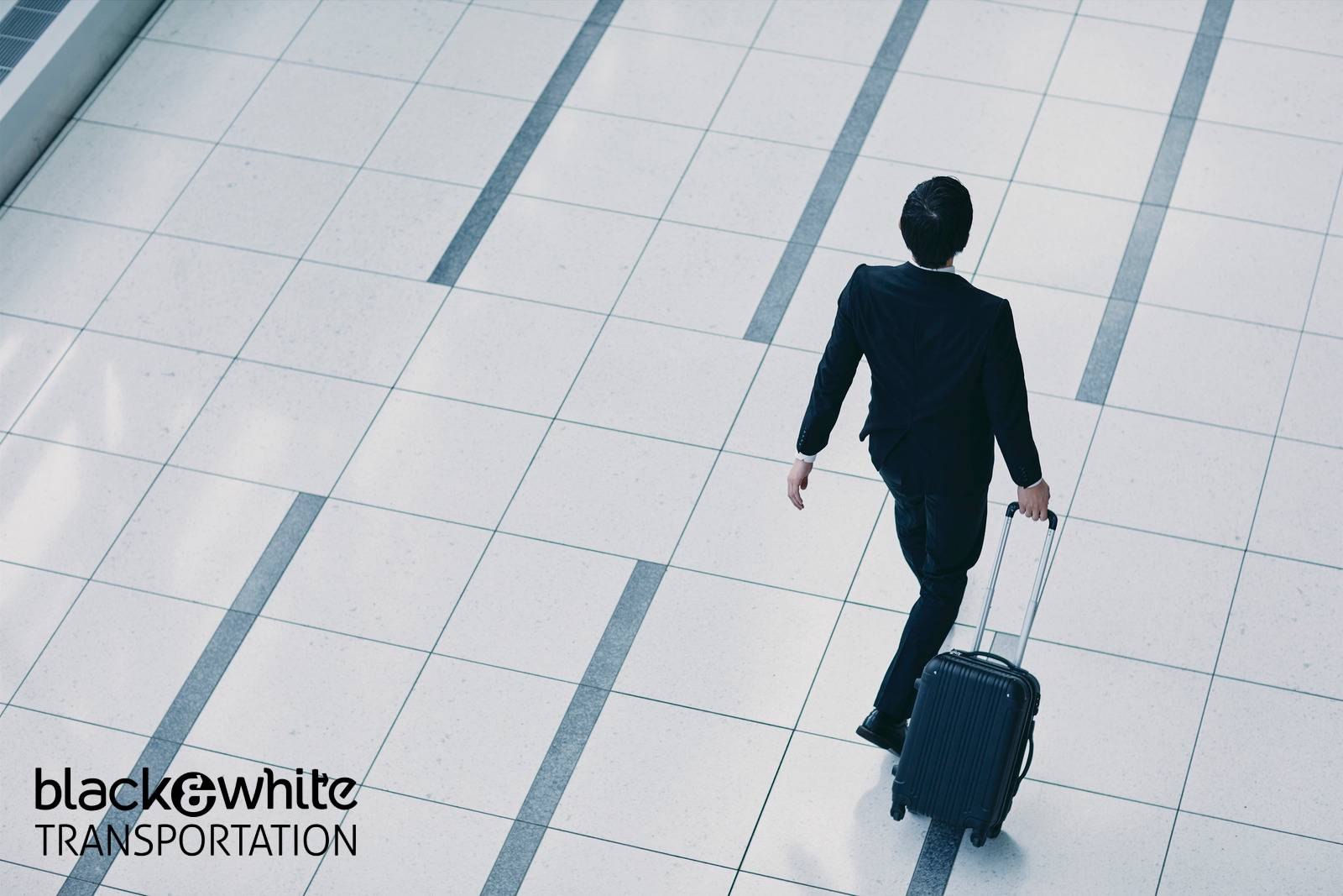 Business Traveler Pulling a Rolling Suitcase Across a Tiled Airport Floor